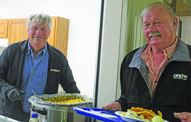 Russ Rice of Broken Bow dishes up the mac &amp; cheese to one of the Fish Fry guests, Don White of Berwyn.