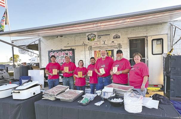 ABOVE: The grill master team of Cookin' With Wood pose for a photo during the Blowin' The Doors Off BBQ in Oconto on June 7. The team won the sauce category and placed in every category except specialty to take the third place overall title. RIGHT: Andrew McKinzie has brought his knowledge and love of meat to the BBQ judging table for several years, and this year helped judge the brisket category where Hooker County BBQ was crowned the champion. (Photos courtesy Brett Eggleston)