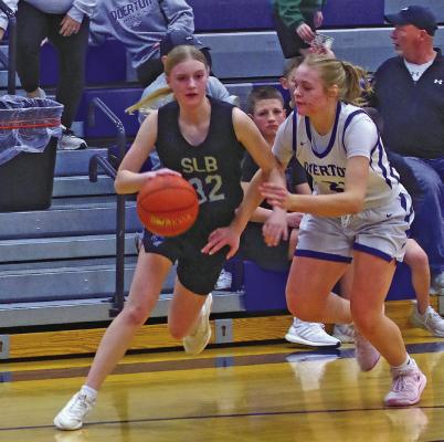 South Loup’s Gracie Brennan tries to get around Halynn Hughes of Overton in the first round of the girls’ D1-10 sub-district tournament in Overton on Feb. 17. (Courier photos by Ronda McFate)