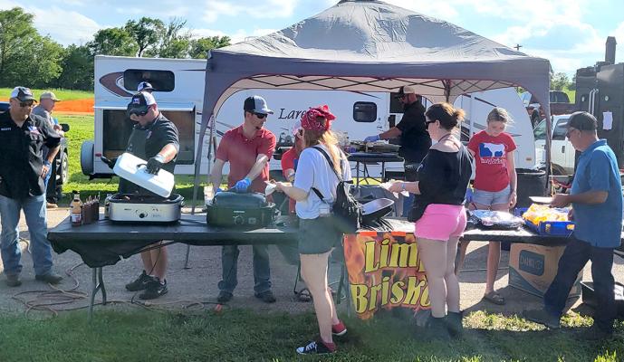 ABOVE: Limp Brisket from Lexington serves their award winning BBQ to attendees of the Blowin' The Doors Off BBQ on June 1. Later that evening the cookers were named Best Overall in the contest.