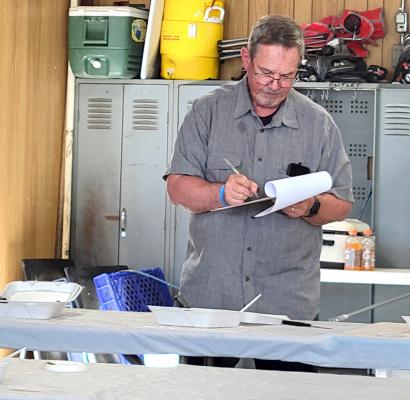Mike Wendorff jots notes down on his judging sheet at the Oconto BBQ on June 1. Wendorff has judged the contest nearly every year of its existence.