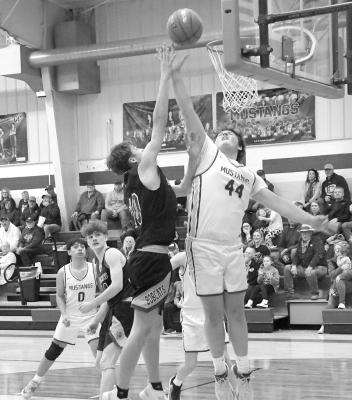 Junior Cohen Rohde tries for the contested layup against #10 Sophomore Dylan Pandorf but he added two for the Bobcats. (Courier photo by Leta Connell)