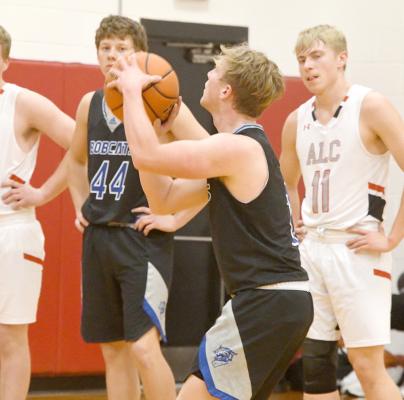 ABOVE: Trey Connell lines up and adds two for the Bobcats in action at Loup City on Jan. 16. LEFT: Joey Sallach attempts to block Ryan Kaslon in the Rebels 6153 overtime win over the Bobcats (Courier photos by Leta Connell)