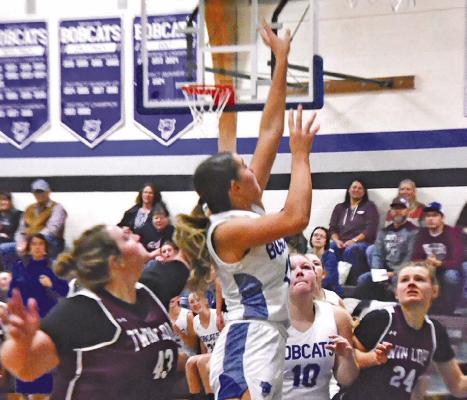 Kamryn Kramer takes the ball to the hoop for South Loup against Twin Loup in the opening game of the season last Friday. Teammate Tyra Brestel (#10) stands ready to assist. (Courier photos by Ronda McFate)