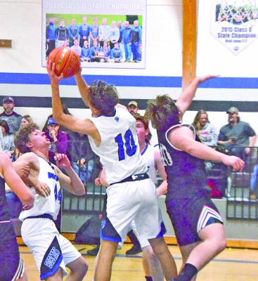 Dylan Pandorf (#10) fights off a Twin Loup defender for the ball, as Crew Witthuhn (#44) is ready to help. (Courier photo by Ronda McFate)