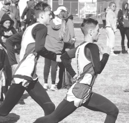 (Left) Cache Gracey and Silas Cool reach their stride in the 800m dash at Burwell. Gracey placed 1st (2:06.40) and Cool 5th (2:11.70).
