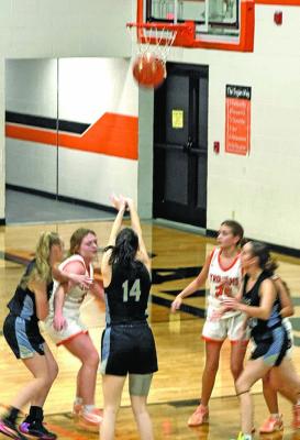 Kelynn Witthuhn (#14) makes good on a 2-point shot against Cambridge on Dec. 12. Helping clear the lane for her are teammates Delanie Weinman, left, and Kaygan Witthuhn. (Photo courtesy Nicole Witthuhn)