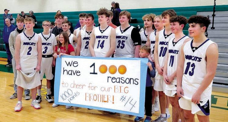 South Loup junior Cache Gracey (#14) scored his 1,000th career point against SEM on Feb. 17. He is surrounded by his teammates and siblings. (Courier photos by Loleta Connel)