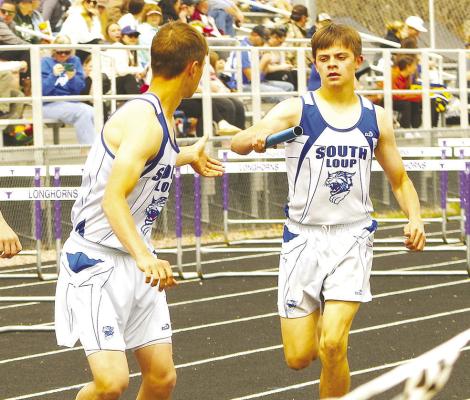 LEFT: Jaden Baker hands the baton to Elijah Cool in the men's 4x800 relay at Burwell last week. The team captured the bronze medal for their efforts. (Courier photo by Ronda McFate)