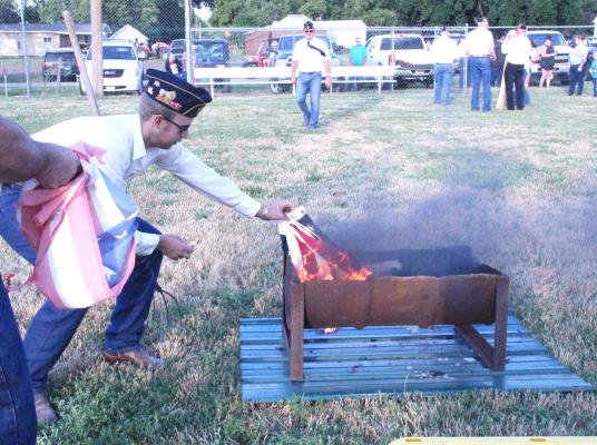 More than 60 worn and tattered American flags were properly disposed of during a ceremony at the ball field in Callaway on July 4. Members of the Callaway American Legion collected the flags and conducted the ceremony. (Courier photos by Ellen Mortensen)