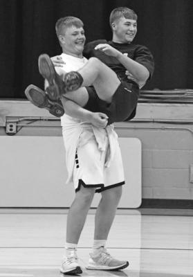 ABOVE: Lance Jones and Joey Sallach in 'baby's cradle' during the Ships and Sailors game. RIGHT: Greeley Hrupek goes table surfing with a little help from the girls at the pep rally Thursday evening. BELOW: The Bobcats go wild cheering on the musical chairs champ.
