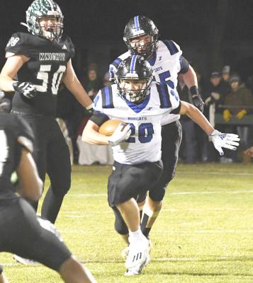 Above: Sophomore Conner Paulsen (#10) and Crew Witthuhn (#44) team up to stop the Sandhills-Thedford Knight's quarterback with a host of Bobcats also on the way. Left: Junior AJ Starr (#20) finds some space and weaves through traffic for a good Bobcat gain. (Courier photos by Loleta Connell)