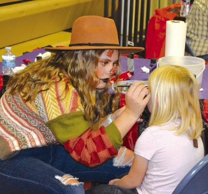 (Top Left) Maggie Birkel decorates a young one’s face (Above) Kids fall carnival in full swing (Below) Neltje Reiff helps out Georgia Guthrie and Gracie Brennan with the Wheel of Fortune Photos courtesy Mike Reiff