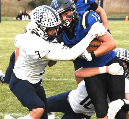 Right: Sophomore Conner Paulsen (#10) secures the ball as Cougar defenders work to strip the ball on the tackle