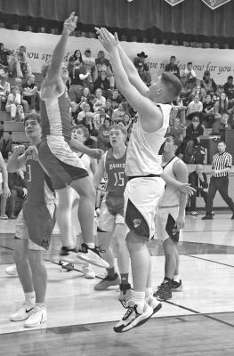 ABOVE: Malachi Neth shoots the short jumper closely contested by a Medicine Valley Raider defender on Friday, Dec. 19.