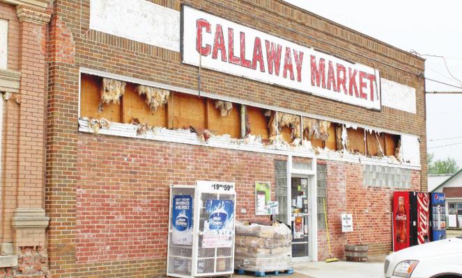 ABOVE: The Callaway Market received heavy hail damage Sunday evening, but was open for business to local residents on Monday morning. LEFT: Lane Hogg stands in front of his family’s heavily damaged home holding the casualty that devastated his little sister - her dolly was a victim of the storm.