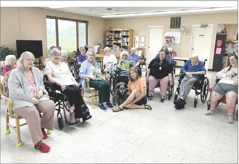 Yvette Mannon and Cookie pose with the residents at Callaway Good Life Center after Mannon shared her new book. They also enjoyed cake and coffee, and a time of conversation and sharing memories. (Photo courtesy Tammy Coons-CGLC)