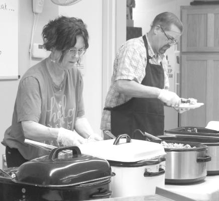 CGLC Administrator Todd Sutherland was assisted by staff member Michelle Brestel in dishing up plates for the residents and their families last Thursday. (Courier photos by Ellen Mortensen)