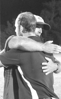 You know it will be a great game with a father versus son match-up like this...Coach Andy Schwarz and Coach Blake Schwarz hug after the game Thursday evening. (Courier photos by Loleta Connell)
