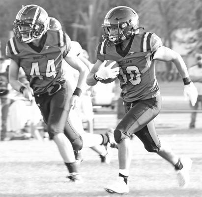 Sophomore Crew Witthuhn watches for the next defender while #10 sophomore Conner Paulsen hits the gap in the Bobcats 48-21 victory over Elm Creek.