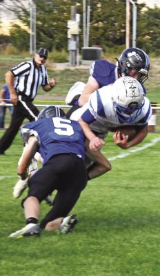 Courier photos by Loleta Connell ABOVE: Juniors Cache Gracey (#5) and Trey Connell (#3) team up for the stop on Parker Provost. RIGHT: Junior Rio Remund (#45) says 'Hold on, not so fast' to senior ball carrier Max Kostman against Hyannis on Friday.