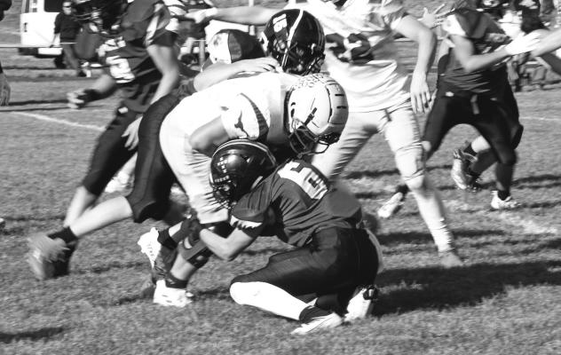 Courier photo by Loleta Connell Sophomore Ethan Furne (#6) does it right with the low tackle on Wyatt Phillips assisted by #15 sophomore Dawson Mason.