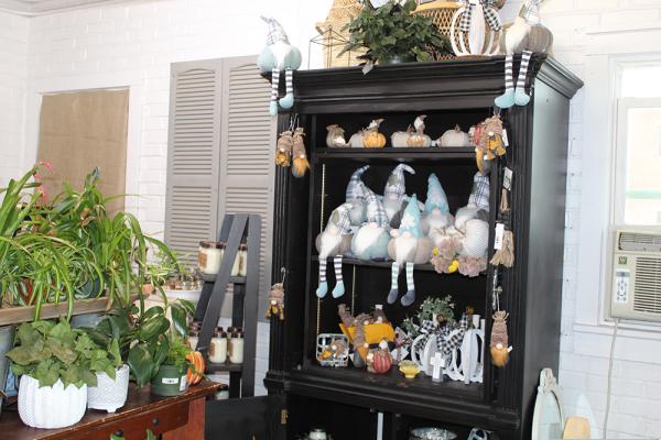 A shelf of fall garden decor and wintery garden gnomes.
