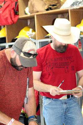 Judges Tim Reith, NTV, and Adam Smith, KRVN, score one of the categories in the 2022 Oconto BBQ competition. 