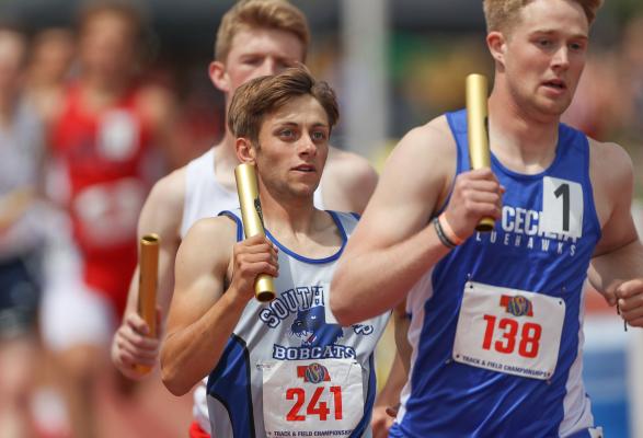 Silas Cool keeps his competitor from Hastings St. Cecelia in his sights during Class C 4 x 800 meter relay action. (Courier photo by Corbey Dorsey)