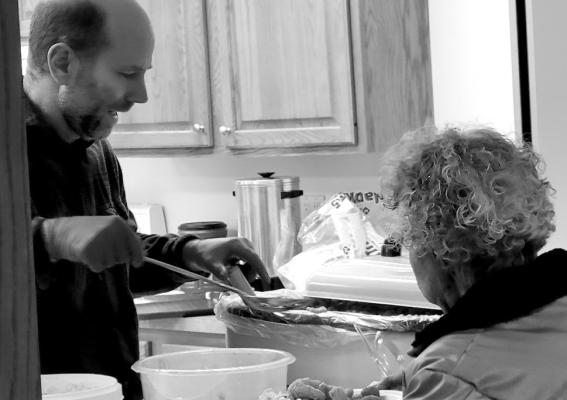 A fish fry attendee waits patiently for a scoop of mac &amp; cheese to accompany her fish, shrimp and salads.