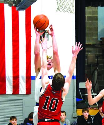 (Above) Sophomore AJ Starr shoots underneath with #10 Junior Rylie Shirk from Brady playing tight defense. (Left) Sophomore Caleb McFate makes a pass from the top of the key against Brady on Saturday. (Courier photos by Loleta Connell)