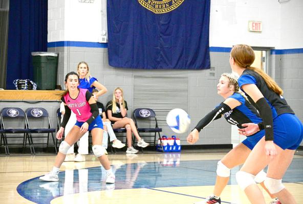 Addison Stump receives the ball for the Lady Bobcats and gets encouragement from her teammates as she makes the return.