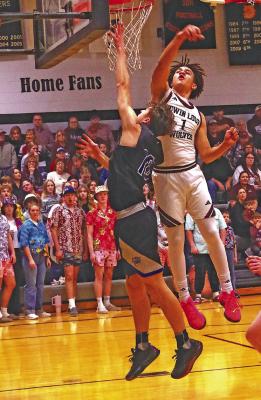 Dylan Pandorf takes the ball to the bucket against Twin Loup while Yahya Harris tries to block the shot for the Wolves.