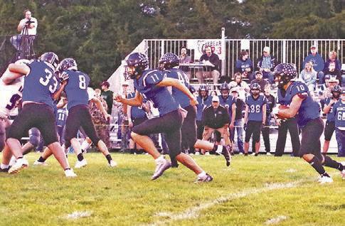 Conner Paulsen (#10) gets the ball as teammates Taytum Wiese (#33), Elijah Cool (#8), Dylan Pandorf (#11) and Crew Witthuhn (#44) try to open up a hole for him to run through.