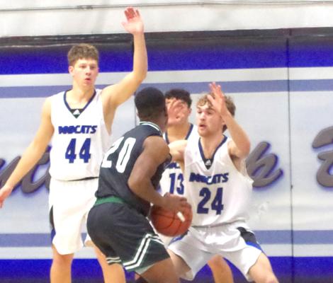 Harper Johnson (#24), Connor Paulsen (#13), and Crew Witthuhn (#44) team up to defend a Sandhills- Thedford player during the Jan. 9 contest in Arnold.
