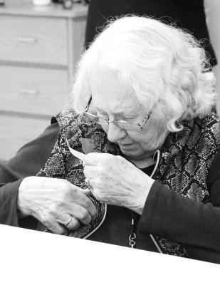 A resident of Callaway Good Life Center pins a poppy to her blouse during the Walk of Flags program at the center on May 26.