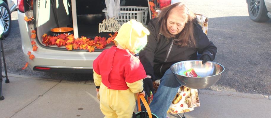 Left: Susanne Longmore puts candy in the bucket of a young trickor- treater at Callaway's Trunk-or-Treat event on Oct. 31. The event is hosted each year in downtown Callaway by the local Chamber of Commerce. Right: The staff of Callaway Good Life Center got in on the costume fun for the Trunk-or-Treat. (Courier photos by Ellen Mortensen)
