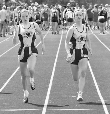 LEFT: Halie Recoy (left) and Bryn Schwarz run the 100 meter dash at the District C-8 meet on Thursday. Schwarz qualified for the state meet with a time of 13.09. RIGHT: Faith Bierman hands off the baton to Heidi Donegan during the 4x800 relay. The relay team of Bierman, Donegan, Ivy Tullis and Talli Martin finished first with a time of 10:47.54 and qualified for state. (Courier photos by Amanda Koubek-Wehnes)