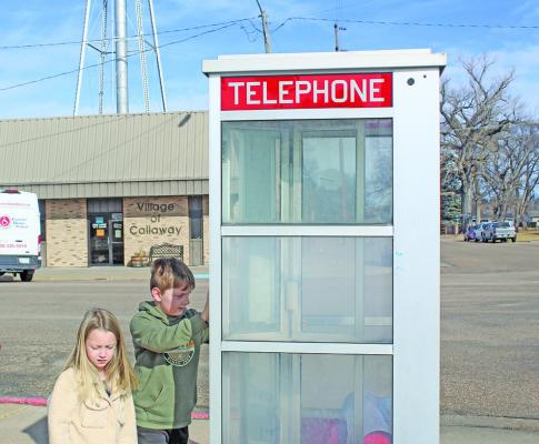 River and Ellie Holland check out a site in downtown Callaway that is unfamiliar to them - a phone booth - while their grandfather explained what it once was. They are the children of CHS alum Tara (Taul) Holland.