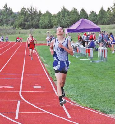 Logan Recoy reacts to crossing the finish line in the 1500 meter run at district track on Thursday. He finished in first place with a time of 5:04.89 and qualified for state. (Courier photo by Amanda Koubek - Wehnes)
