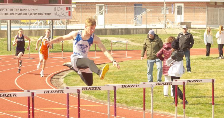 CJ Quandt leaps over a hurdle at the Hi-Line Invitational track meet held in Elwood on April 1. Quandt earned the 4th place medal in the event for the Bobcats. (Courier photos by Ronda McFate)