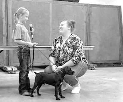ABOVE LEFT: Rickey Viter and Kaedyn Weinman are all smiles as they prepare for the small animal pet show on Sunday. (Photo courtesy Jessi Viter) ABOVE: Members of the South Loup 4-H club clean and prepare stalls for their livestock. LEFT: Some of the chickens waiting to be shown at the Poultry Show on Tuesday. RIGHT: Kaedyn Weinman is interviewed by a judge during the pet show on Sunday. (Photo courtesy Jessi Viter)