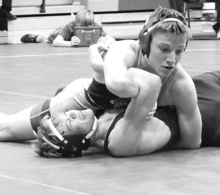 Above: Dawson Mason works to get his opponents shoulders pinned to the mat at the Hi-Line Invite on Dec. 1. Mason picked up the silver medal at the tournament. Left: CJ Quandt watches the referee closely for the signal of a successful pin at the Twin Loup Tournament on Dec. 9.