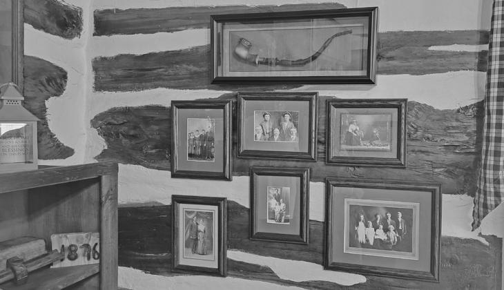 Old family photos and the original pipe belonging to homesteader Paul Seyerson adorn the walls of the log home he built in 1880 on the property he homesteaded in 1876. (Courier photo by Ellen Mortensen)