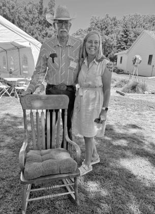 Dave Chesley became emotional as a cousin, Gretchen Goral of Longmont, Colorado, presented him with their grandma Anna Chesley’s rocking chair. The chair now sits prominently in the log house where Anna grew up, and Dave now lives. (Photo courtesy Jo Chesley)