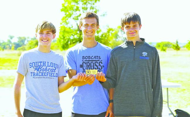 From left: Walter Bierman, Josiah Coleman, and Jaden Baker hold the cross country conference team championship plaque. Team member Eli Rogers is not pictured. (Courier photos by Ronda McFate)