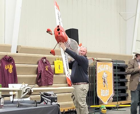 Callaway Community Foundation President Corby Leeper holds up a large model airplane during the Foundation Gala live auction Saturday night. The plane was one of nearly 60 live auction items available for purchase. (Courier photo by Ellen Mortensen)