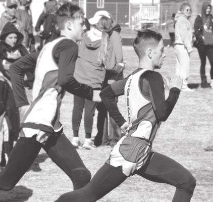 (Left) Cache Gracey and Silas Cool reach their stride in the 800m dash at Burwell. Gracey placed 1st (2:06.40) and Cool 5th (2:11.70).