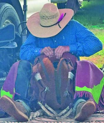 Quinton Boeser works to get his saddle and equipment ready prior to competing in the junior high nationals last month.
