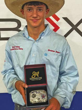 Quinton Boeser proudly displays the silver belt buckle he earned with a top 10 finish at the National Junior High Finals Rodeo.